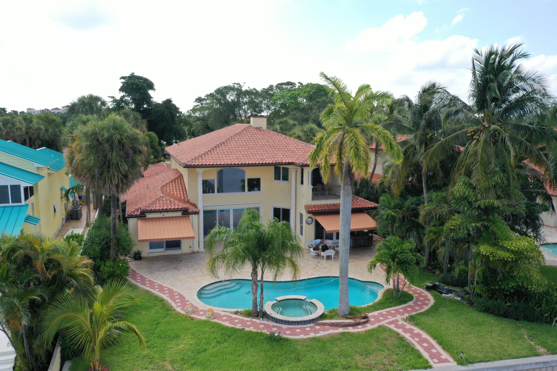 A large house with palm trees and a pool.