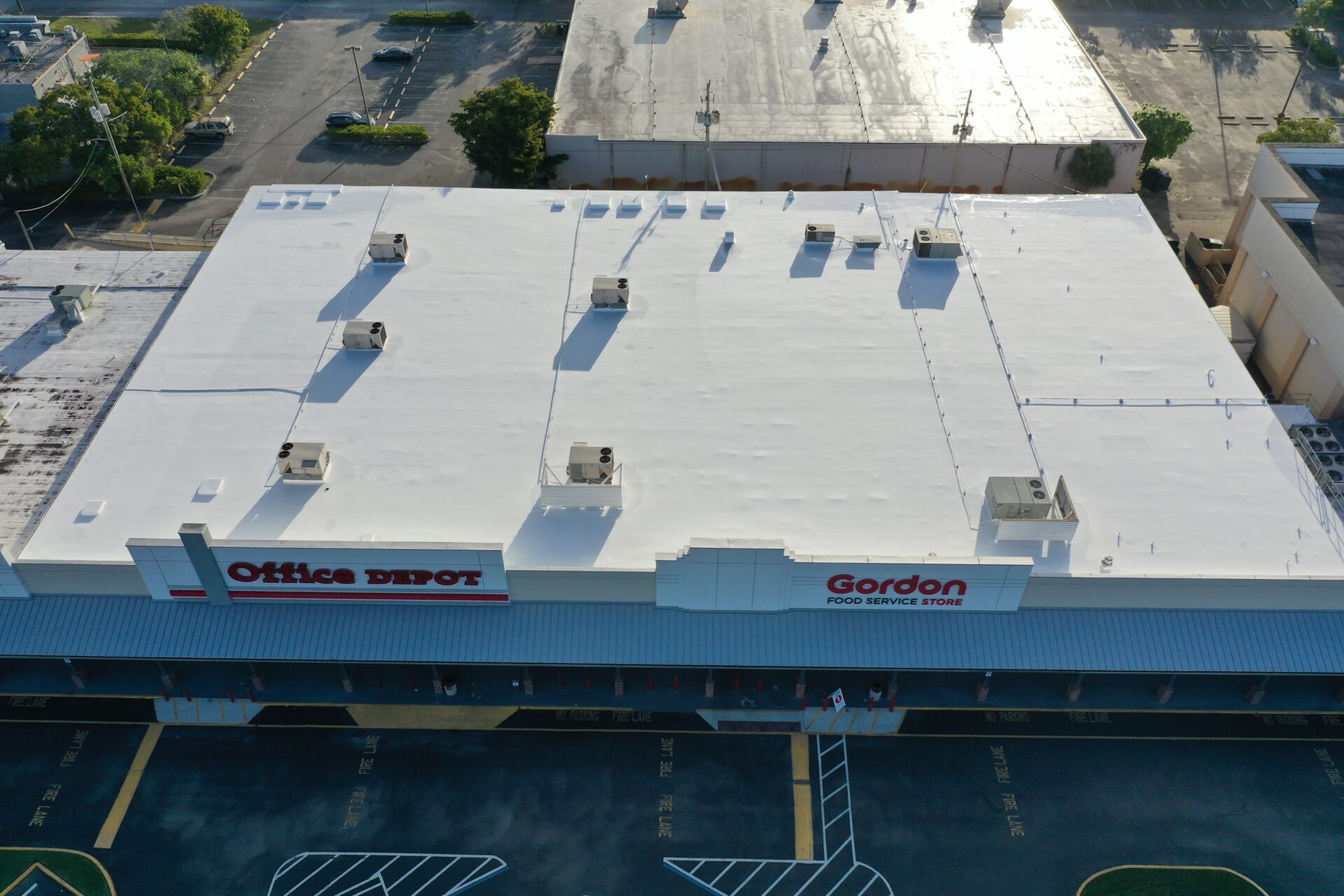 A large white building with several parking spaces.